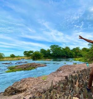 一名男子站在河边,伸出手臂