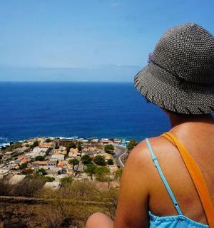 a person wearing a hat looking out at a city