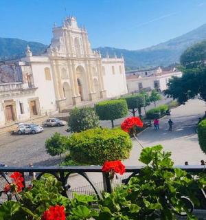 a view of a building from a balcony with red flowers