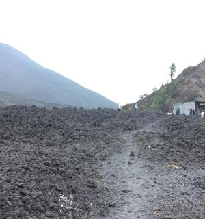 a little girl standing on top of a rocky hill