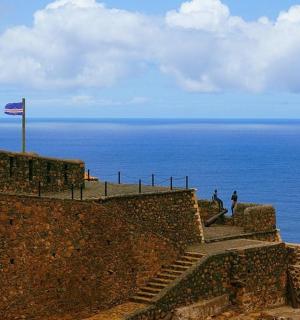 a flag on top of a wall near the ocean
