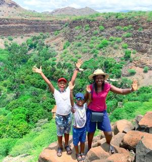 一名妇女和两个孩子站在山顶上
