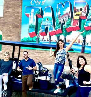 skupina lidí pózujících pro fotografii před cedulí