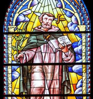 一扇彩色玻璃窗,窗上画着一名男子举着牌子