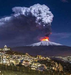a eruption of a volcano at night with flames and smoke