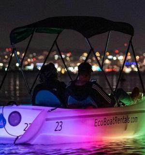 skupina lidí v lodi ve vodě v noci