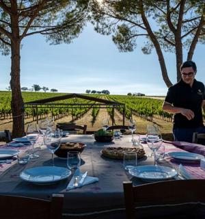 žena stojící před stolem se sklenicemi na víno