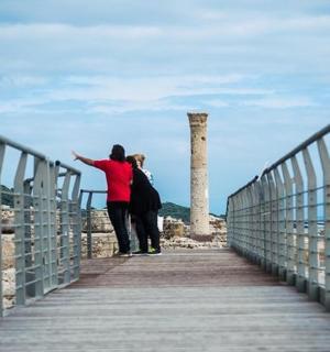 两个人站在海滩的木板路上