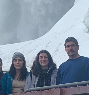 a group of people standing in front of a mountain