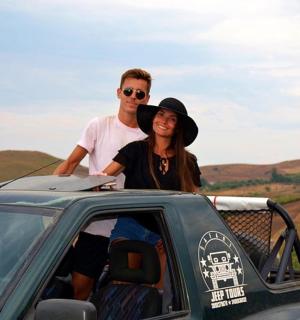 a man and a woman standing in the back of a car