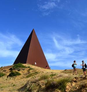 dva lidé stojící na vrcholu kopce s pyramidou