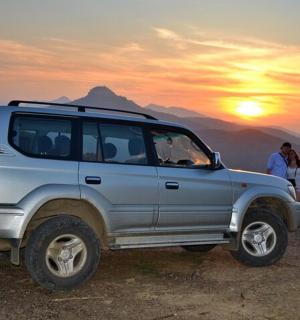 รถ SUV สีเงินจอดอยู่บนยอดเขา