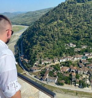 a man standing on a ledge looking down at a city