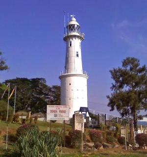 山上的一座灯塔，前面有一块标志牌