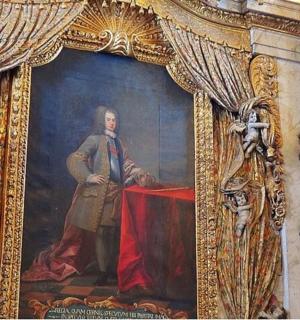 一幅画，画中一名男子坐在桌边