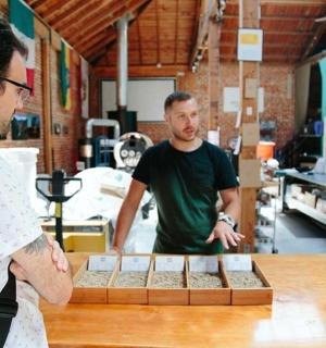 两个男人和另一个男人站在厨房的桌子旁