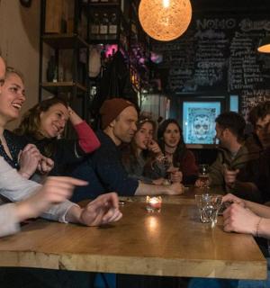 skupina lidí sedících u stolu v baru