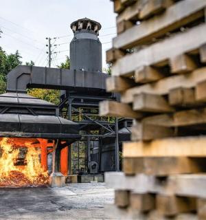 oheň hořící v kovárně s věží v pozadí