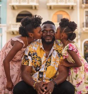 一名男子在街上拥抱两名女子