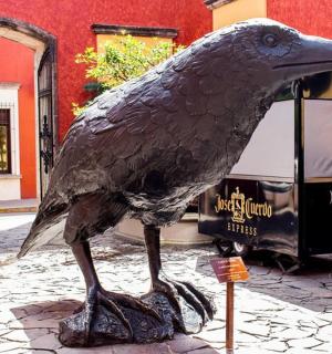 a statue of a bird standing in front of a bus