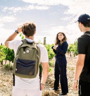 一群人站在葡萄园里看着一个女人