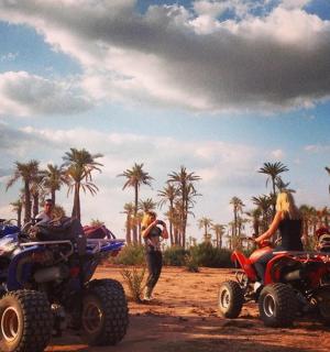 一群人骑着四轮摩托车在土路上行驶