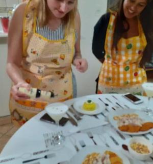 两位女士站在摆满食物的桌子旁