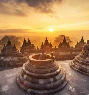 a view of a temple with the sunset in the background