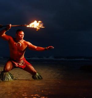 muž drží na pláži pochodeň