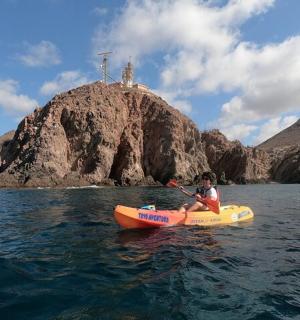 a person in a kayak in the water in front of an island
