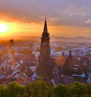 a city skyline with a clock tower at sunset