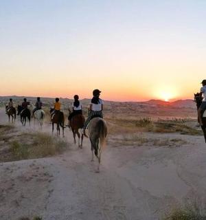 a group of people riding horses in the desert