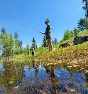 一名男子站在池塘边钓鱼