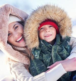 žena a dítě se objímají ve sněhu