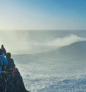 一群人坐在岩石上望着大海
