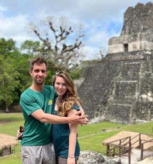 a man and a woman standing in front of a temple