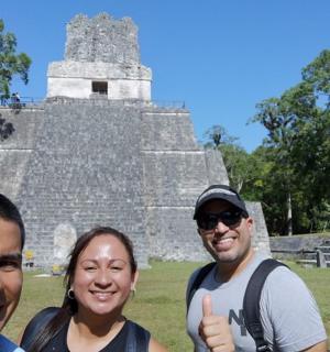 三个人在寺庙前竖起大拇指