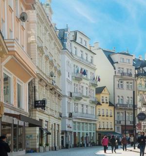 a group of people walking down a street with buildings