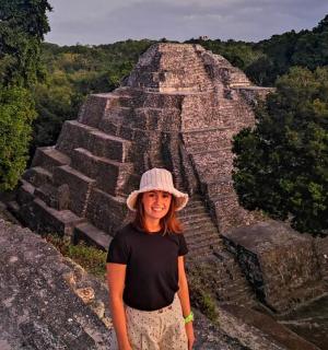 a woman standing at the mayan pyramid
