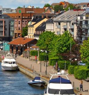 a group of boats docked in a river with buildings