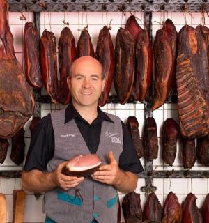 a man standing in front of a rack of meat