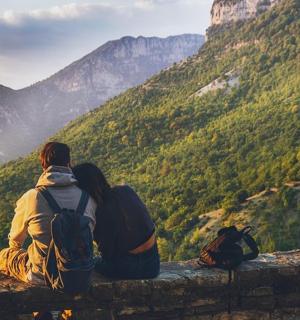 一对夫妇坐在窗台上望着山