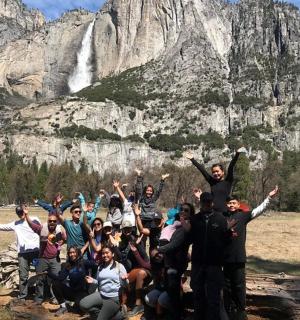 a group of people posing for a picture in front of a mountain