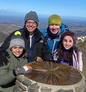 skupina lidí stojící na vrcholu hory