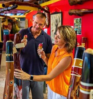 a man and woman standing in a store looking at vases