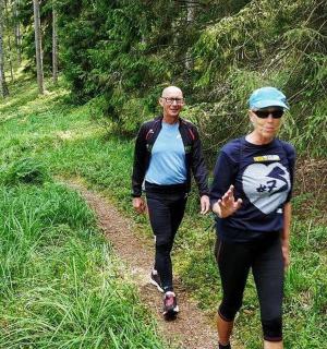 dva lidé jdoucí po stezce v lese