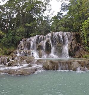 a waterfall in the middle of a pool of water