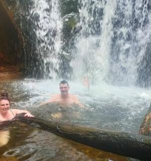 a man and a woman swimming in a waterfall