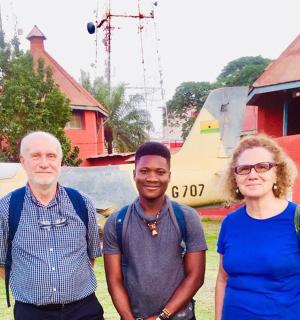 a group of three people standing in front of a plane