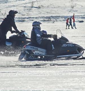 两个人在雪地里骑着雪地摩托